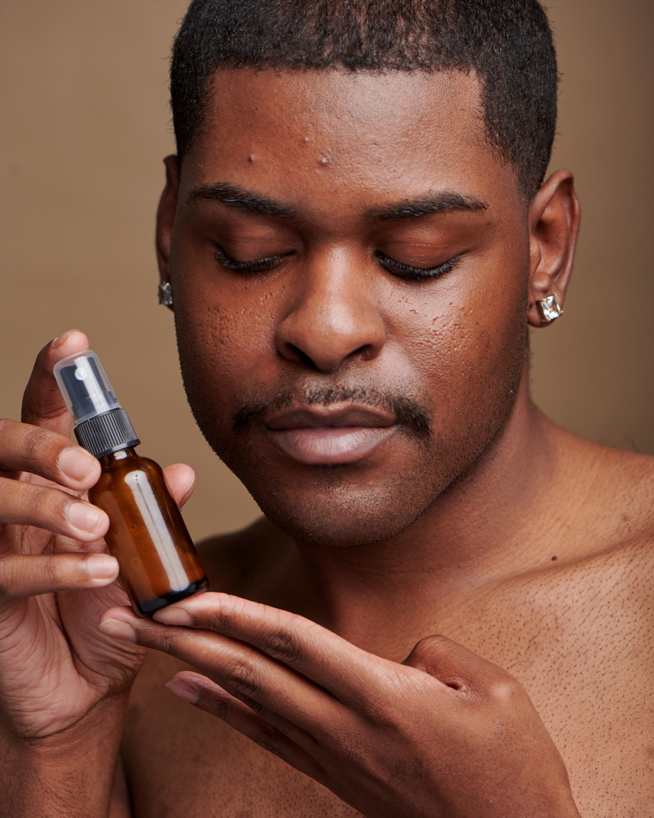 Man Holding Bottle of Skincare Product